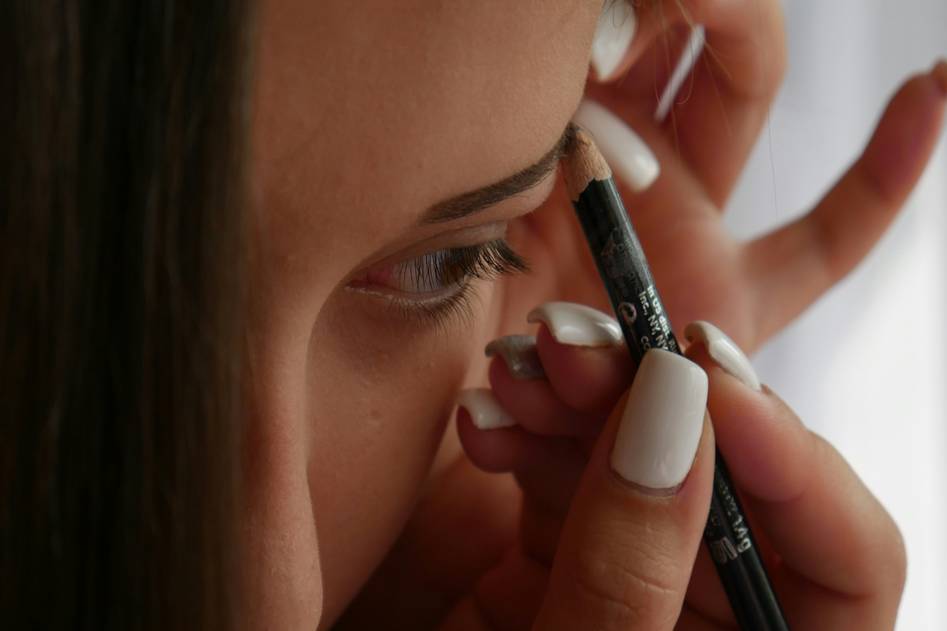 Assortment of high-quality eyebrow brushes including spoolies, angled brushes, and dual-ended tools arranged neatly on a pastel pink cloth