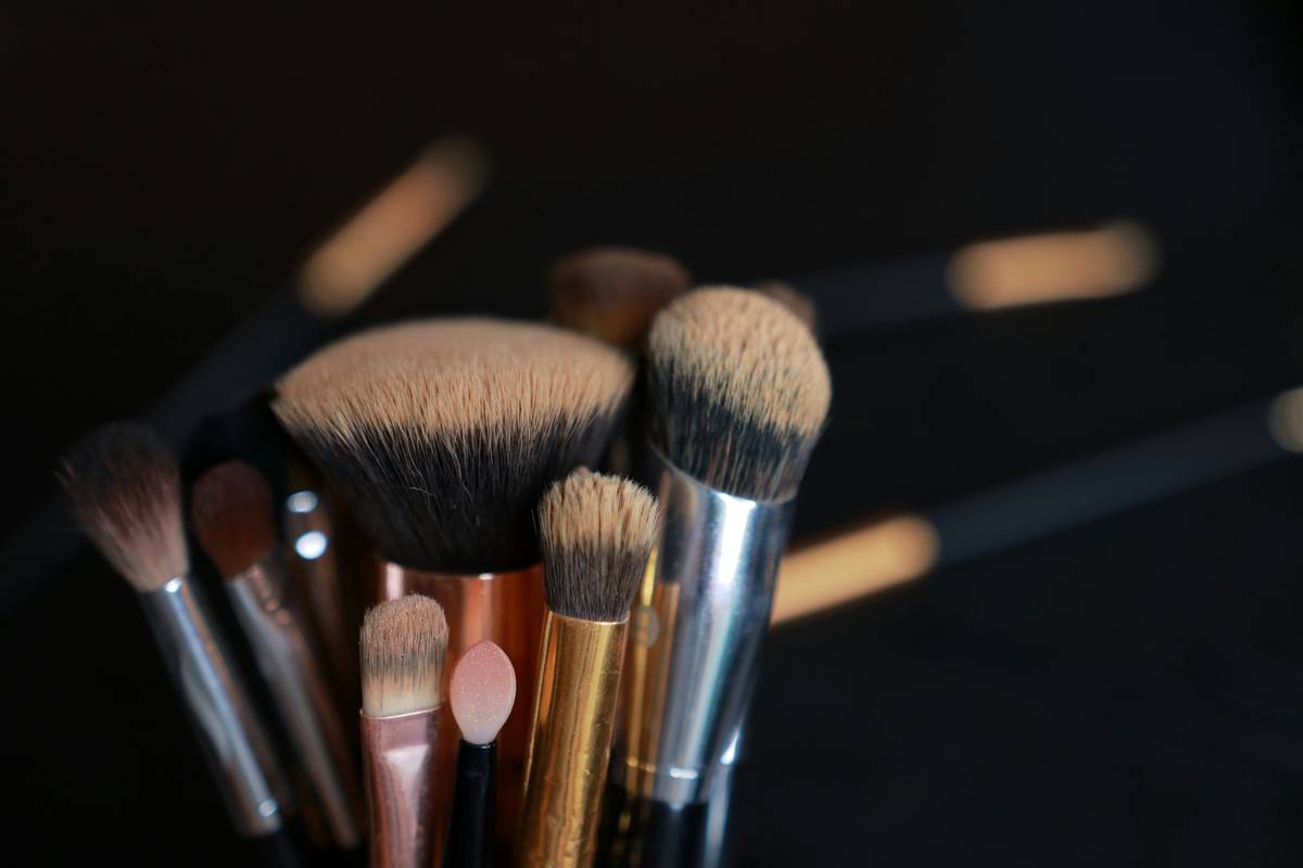 Close-up of a cosmetic spoolie brush styling neatly groomed eyebrows